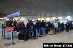 Disa udhëtarë në aeroportin e qytetit të Domodedovo, Rusi.