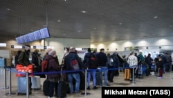 Пассажиры у стоек регистрации в аэропорту Домодедово, Москва, Россия, иллюстрационное фото