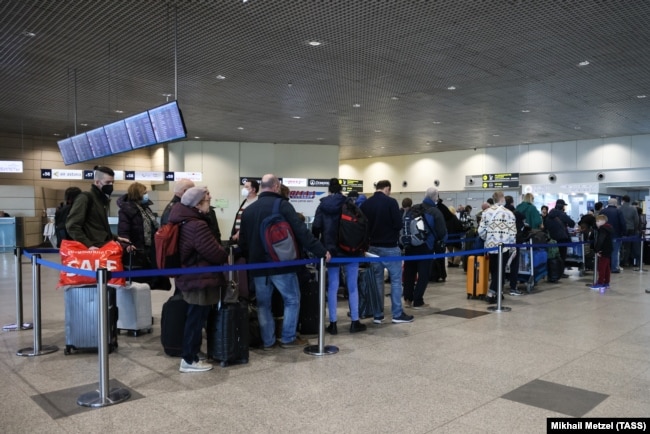 Disa udhëtarë në aeroportin e qytetit të Domodedovo, Rusi.