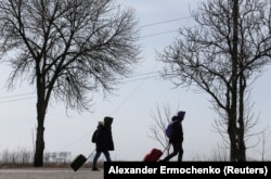 Люди пішки йдуть по дорозі у бік виходу з Маріуполя, 20 березня