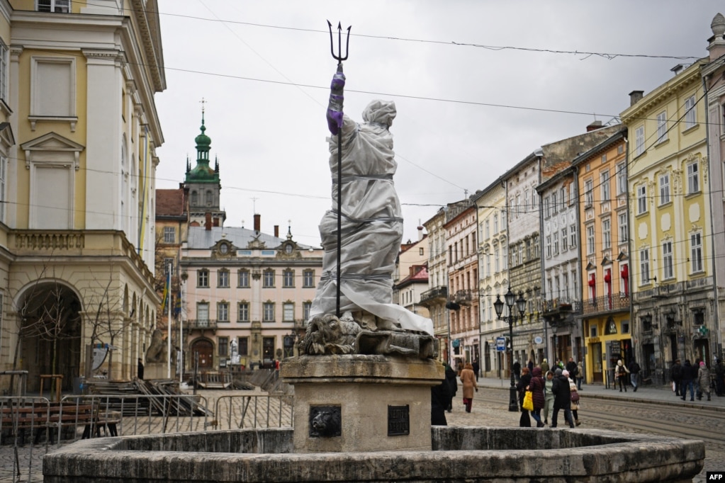 Një statujë e mbështjellë e Neptunit në qendër të Lvivit. Ditëve të fundit, banorët e Lvivit kanë mbështjellë artin në qendrën historike të qytetit, në përpjekje për t’i mbrojtur nga sulmet me raketa, të cilat druajnë se mund të godasin qytetin perëndimor të Ukrainës.  