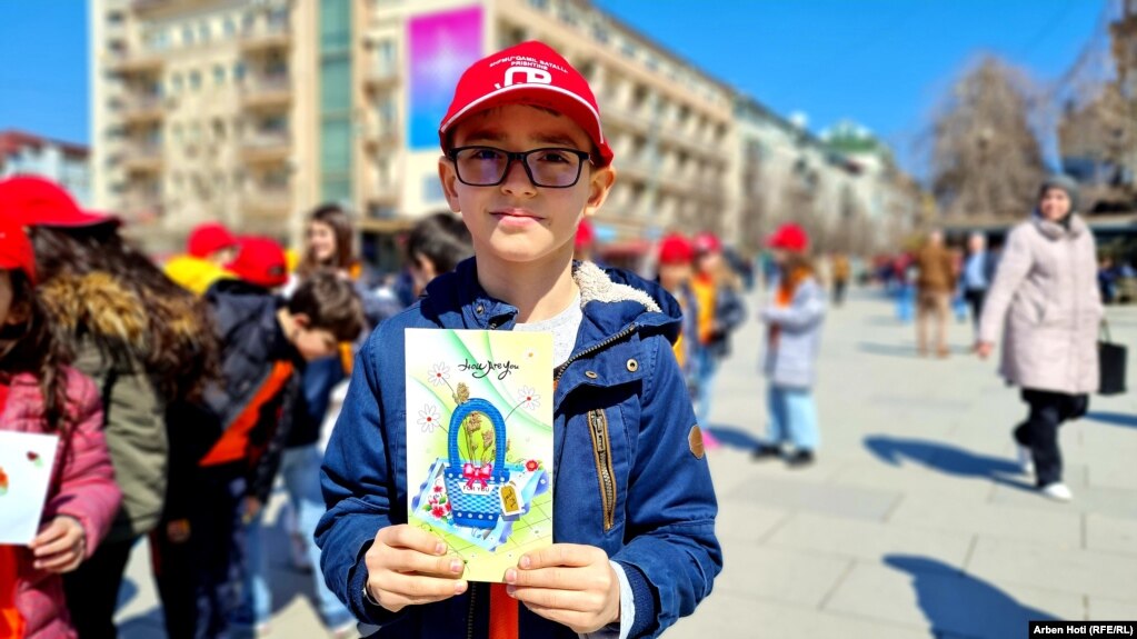 Një tjetër fëmijë tregon një kartolinë të punuar nga anëtarët e shoqatës "Down Syndrome Kosova".