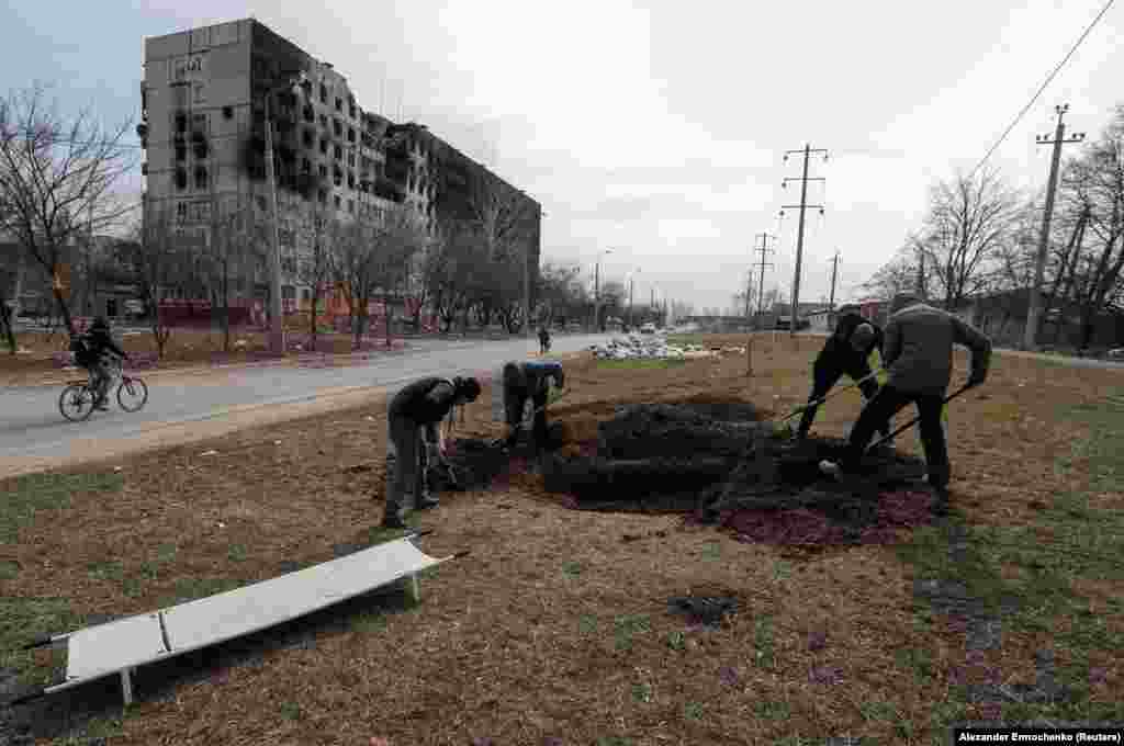 People dig graves for victims killed in the besieged Ukrainian city of Mariupol.&nbsp;