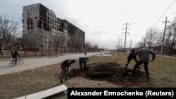 People dig graves where they can for victims of the Russian bombardment in Mariupol on March 20.