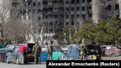 Российские военные проверяют автомобили мирных жителей в Мариуполе, Украина, 20 марта 2022 года 