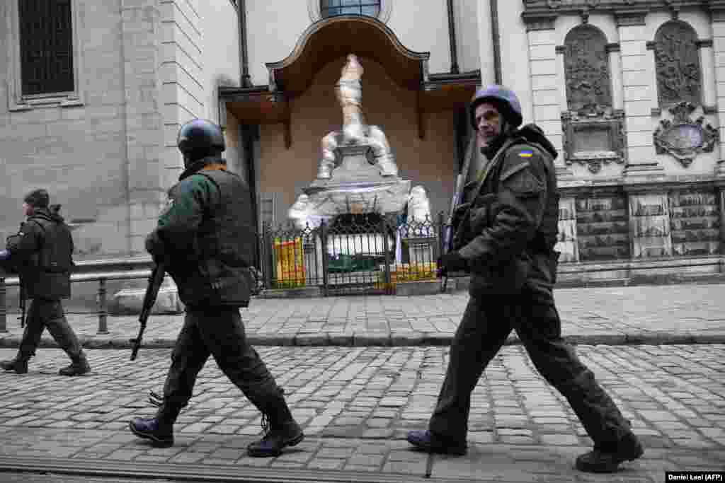 Ukrainian servicemen walk past wrapped statues outside the Latin Cathedral. &nbsp; Lilia Onyschenko, the head of the Lviv Department of Historic Environmental Protection, says the city is home to monuments &ldquo;that represent the architecture of different periods, as well as different nationalities who have historically lived in Lviv, namely Armenians, Germans, Poles, Jews, and Ukrainians.&rdquo; &nbsp;