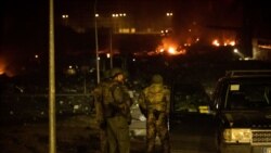 Ukrajinski vojnici u blizini skladišta koje je pogođeno ostacima oborene rakete u Kijevu, 20. mart