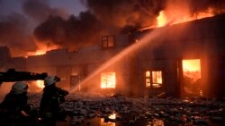 Ukrajinski vatrogasci gase požar u skladištu nakon bombaškog napada u predgrađu Kijeva, 17. mart 2022.