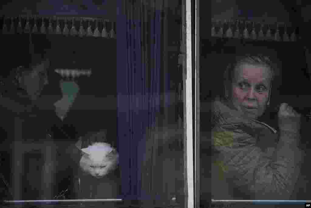Menekültek várakoznak egy buszon, hogy az ukrán rendőrség ellenőrizze a papírjaikat és holmijukat az ukrajnai Brovariban 2022. március 20-án, miután 1600 embert &ndash; akiknek a fele gyerek &ndash; evakuáltak az orosz katonai ellenőrzés alatt álló Bobrikból