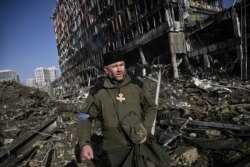 Kapelan ukrajinske vojske Mikola Madenski prolazi kroz ruševine ispred uništenog tržnog centra Retroville u Kijevu, 21. mart