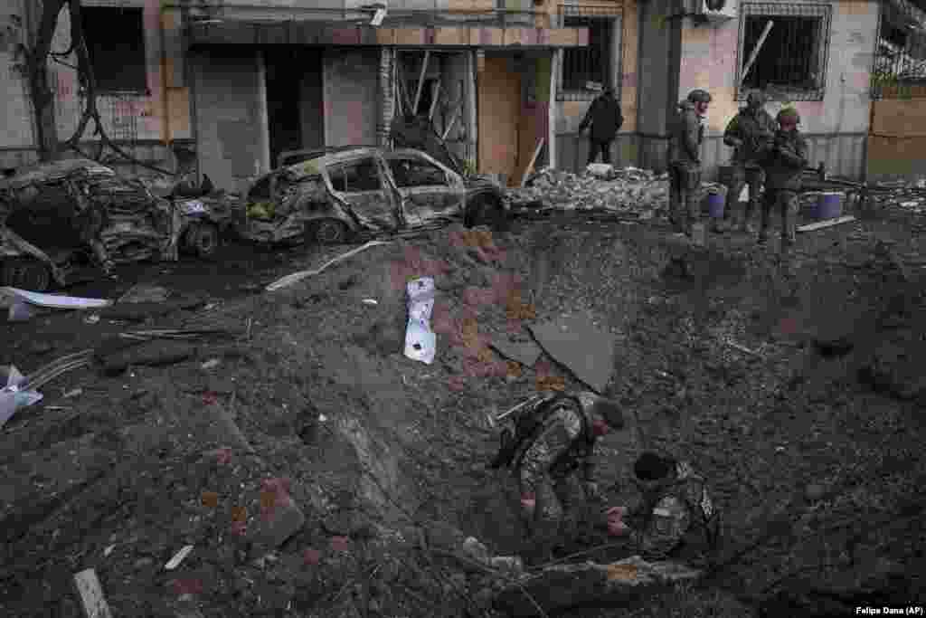 Ukrán tűzszerészek ellenőrzik egy robbanás helyszínét Kijevben március 20-án