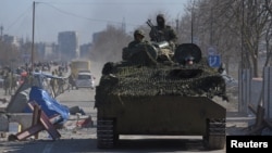 Trupe u uniformama bez oznaka koje podržava Rusija voze se u oklopnom vozilu u opkoljenom ukrajinskom lučkom gradu Mariupolju, 19. mart 2022. 
