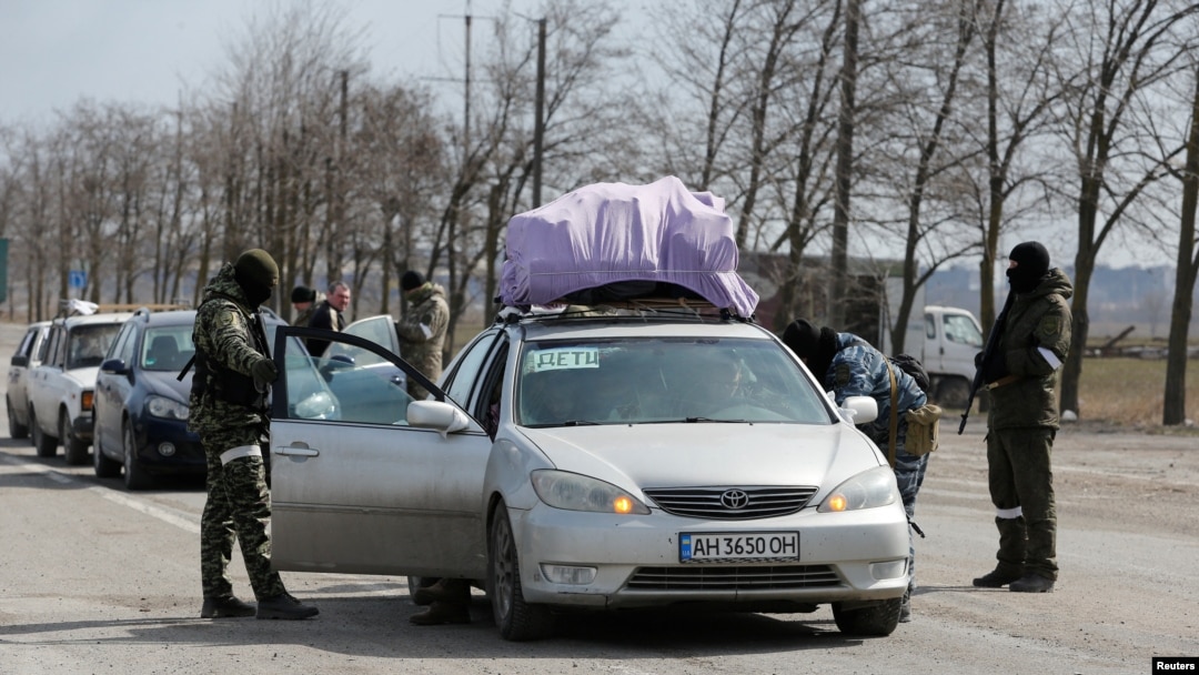 Russian troops check the cars of local residents as they leave the besieged southern port city of Mariupol in Ukraine on March 20. 