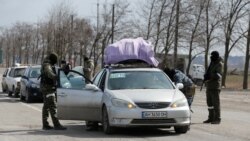 Ruski vojnici provjeravaju automobile lokalnih stanovnika dok napuštaju opkoljeni južni lučki grad Mariupolj, 20. mart