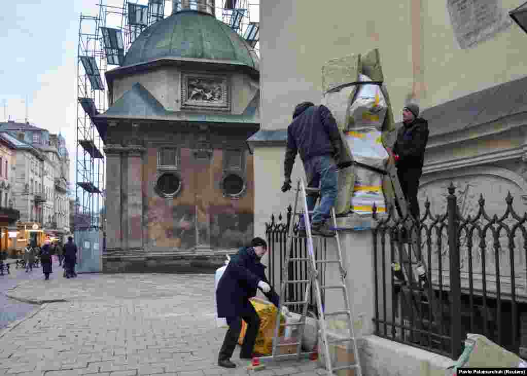 Men wrap a statue in the center of Lviv. &nbsp; A local icon painter involved in the effort to safeguard the historic art of Lviv told RFE/RL&rsquo;s Ukrainian Service &nbsp;that &ldquo;if there is a direct hit from a missile, nothing will help.&rdquo; But such wrapping, which includes fireproof fabric, is an effort to protect Lviv&rsquo;s treasures as much as possible from shrapnel and fire.&nbsp;