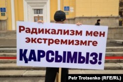 Участник митинга в поддержку президента Касым-Жомарта Токаева прячется от камеры. Алматы, 19 марта 2022 года