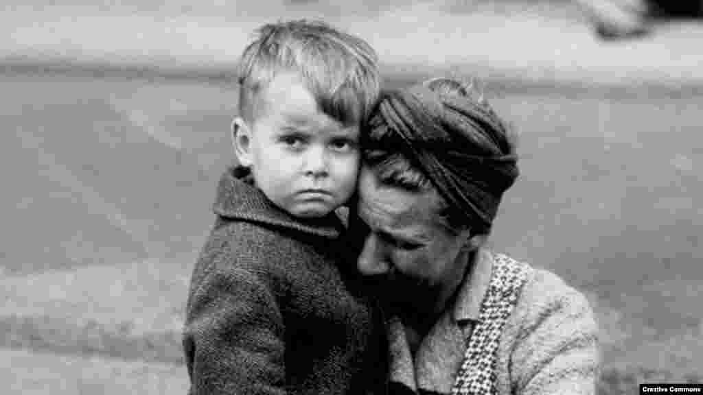 Немецкая женщина с сыном плачет, увидев разрушенный дом в январе 1945 года в Берлине, и украинка с сыном&nbsp;плачет в бальном зале, переоборудованном во временное убежище в Сучаве (Румыния)