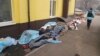 A police officer walks past the bodies of people killed by shelling outside Hospital No. 3 in Mariupol.