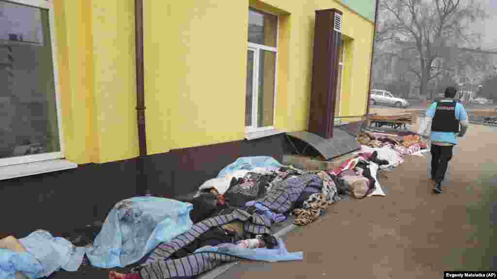 Russia -- A police officer walks past the bodies of people killed by shelling