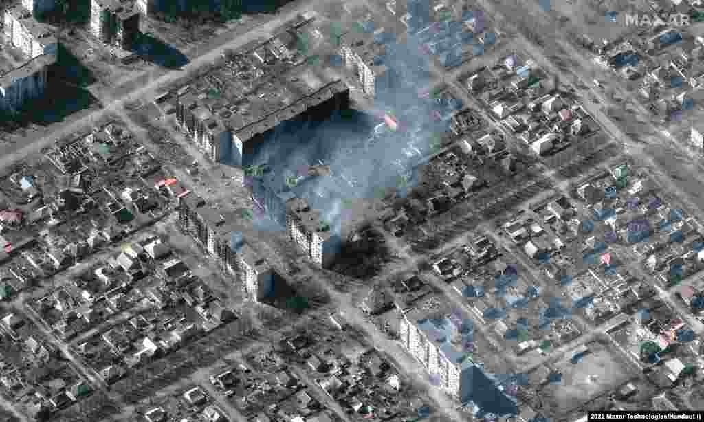 Дым над поврежденными в результате российских ракетных обстрелов жилыми домами Мариуполя, 22 марта 2022 года. Satellite image &copy;2022 Maxar Technologies