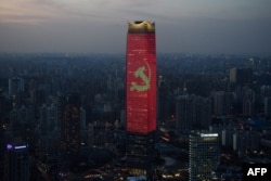 A Kínai Kommunista Pár sarló-kalapácsos logóját hirdeti egy sanghaji felhőkarcoló 2021. augusztus 31-én