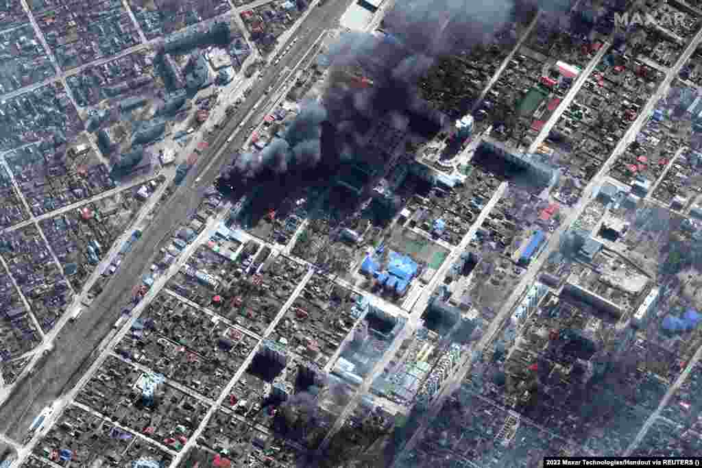 Оштетените, запалени згради се видливи во Ирпин, на северозападниот раб на Киев, на 21 март.