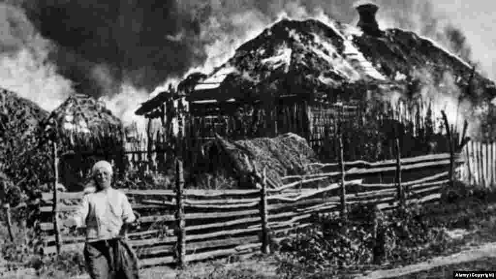 Egy asszony sír lángokban álló háza előtt a Szovjetunió 1943-as náci megszállása alatt &ndash; Irpinyi háza előtt sír egy nő, akinek találat érte otthonát, amely kigyulladt 2022. március 4-én