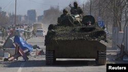 Војници поддржани од Русија во униформи без ознаки во оклопно возило во опколениот украински пристанишен град Мариупол на 19 март.