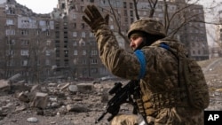 A Ukrainian soldier takes up a position in Mariupol.