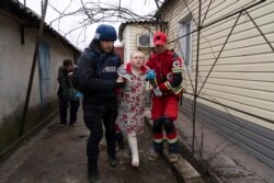 Fotograf AP-a Evgenij Maloletka pomaže medicinarima u transportu žene koja je ranjena tokom granatiranja Mariupolja 2. marta 2022.