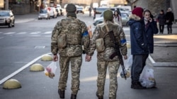 زوج اوکراینی سرباز در حال عبور از خیابانی در پایتخت اوکراین