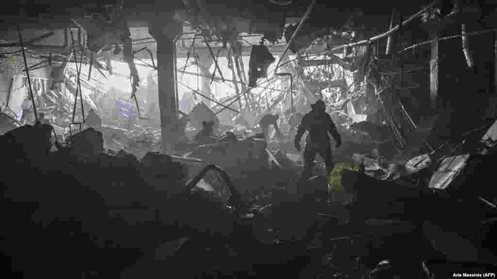 Ukraine -- A Ukranian serviceman walks between debris 