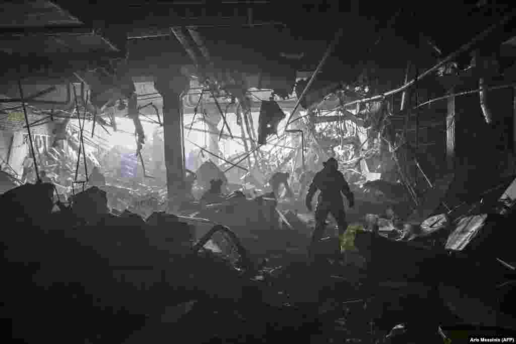 &nbsp;A Ukrainian serviceman picks his way through debris inside the Retroville shopping mall after a Russian rocket attack on March 21.&nbsp;