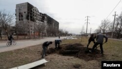 Ljudi kopaju grob na ulici u opkoljenom južnom lučkom gradu Mariupolju, Ukrajina, 20. marta 2022. 