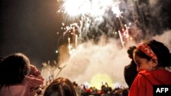 People watch fireworks light the sky as they attend a ceremony celebrating Norouz, the Persian New Year, at the Iran Mall shopping center in Tehran on March 20.