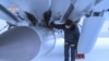Ресейдің МиГ-31 әскери ұшағының астына ілінген "Қанжар" гипердыбыстық зымыранын тексеріп тұрған адам.