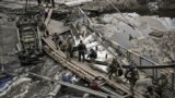 Оборонці Ірпеня перетинають річку через зруйнований. 13 березня 2022 року