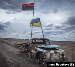 Flamuri ukrainas dhe ai i Ushtrisë Kryengritëse të Ukrainës (majtas) fotografuar pranë vijës së parë të luftës midis forcave ukrainase dhe separatistëve të mbështetur nga Rusia, më 2019.
