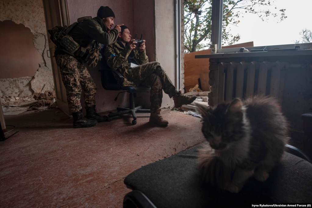 Dy ushtarë dirigjojnë një dron nga një pozicion në një shtëpi në një vend të paidentifikuar ,në tetor.
