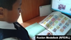 Ученик начальных классов с учебником английского языка. Алматы, 5 сентября 2013 года.