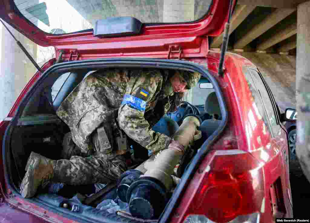 Tetiana Chornovol, a former deputy in the Ukrainian parliament who is now a service member and the operator of an anti-tank weapons system, pulls an anti-tank missile out of a car at a position on the front line in the Kyiv region amid the Russian invasion.