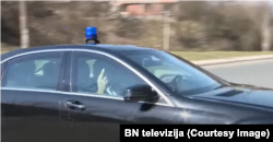 Dodik u službenom automobilu pokazuje ono što liči na "srednji prst" okupljenim novinarima i snimateljima ispred Tužiteljstva BiH, 22. mart 2022.