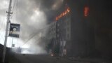 Пожарникари гасят сграда в украинската столица Киев след руска атака. 
