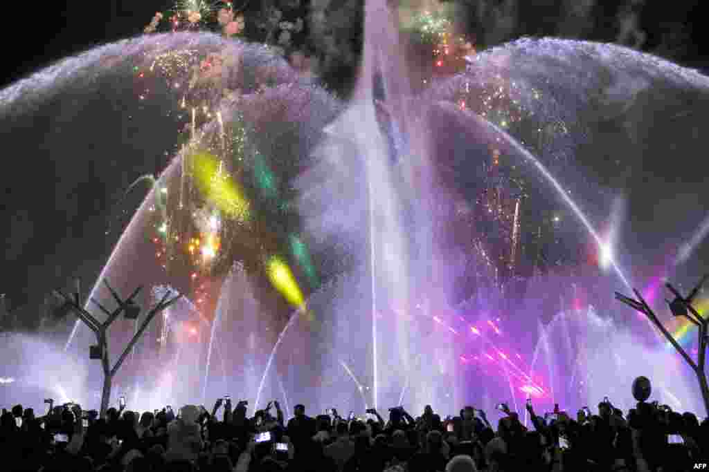 People watch a water show in Tehran.