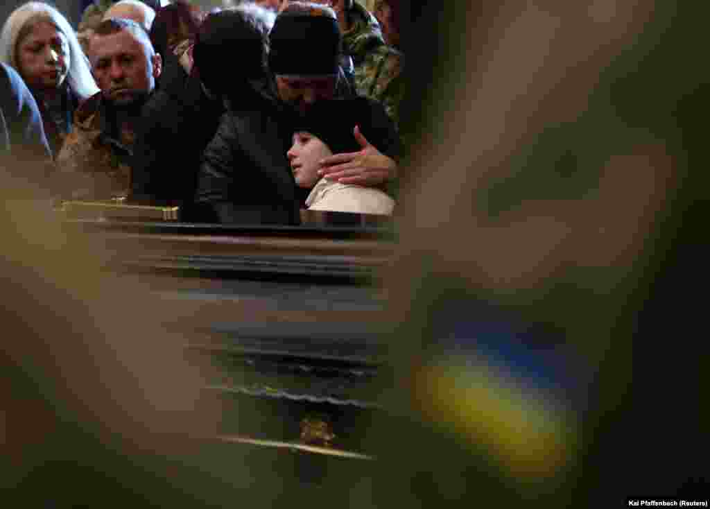 Négy elesett ukrán katonát kísérnek végső útjára szeretteik és hozzátartozóik a lvivi temetőben március 15-én. A katonák egy javorivi katonai bázis elleni rakétatámadásban haltak meg