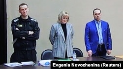 Russian opposition leader Aleksei Navalny (left) is seen with his lawyers Olga Mikhailova and Vadim Kobzev during a court hearing in March 2022.