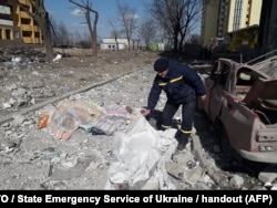  Мъж покрива телата на жертви след обстрел в Чернигов. Снимката е от 17 март 