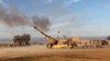 قوات عراقية قرب الدور توجه ضربات مدفعية لمواقع داعش في 8 آذار 2015 