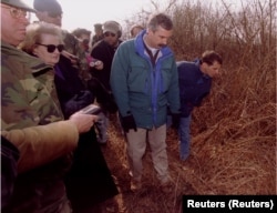 Madeleine Albright i zapovjednik mirovnih snaga NATO-a za Bosnu, admiral Leighton Smith (lijevo) razgledavaju mjesto masovne grobnice u blizini Janje, u sjeveroistočnoj Bosni, 22. marta 1996. Albright je tada vidjela ljudske ostatke, uključujući kosti i raspadnuto tijelo, sumnjivo mjesto masovne grobnice.