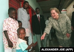 Madeleine Albright sa siročadima iz Burundija, 1996. godine. Albright, je tokom posjeta Burundiju nakon obilaska Liberije i Angole, izjavila da međunarodna zajednica ne želi vidjeti kako ta srednjoafrička zemlja tone "u očajničkom ponoru nasilja".